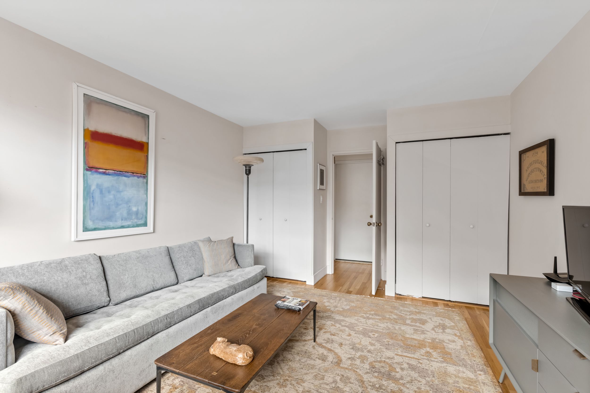 63 Downing Street, Unit 8C Manhattan, NY 10014 - Photo 11 of 15 a living room with furniture and a flat screen tv