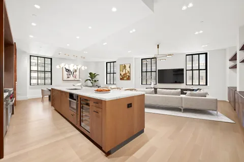 a large white kitchen with a large window and couch