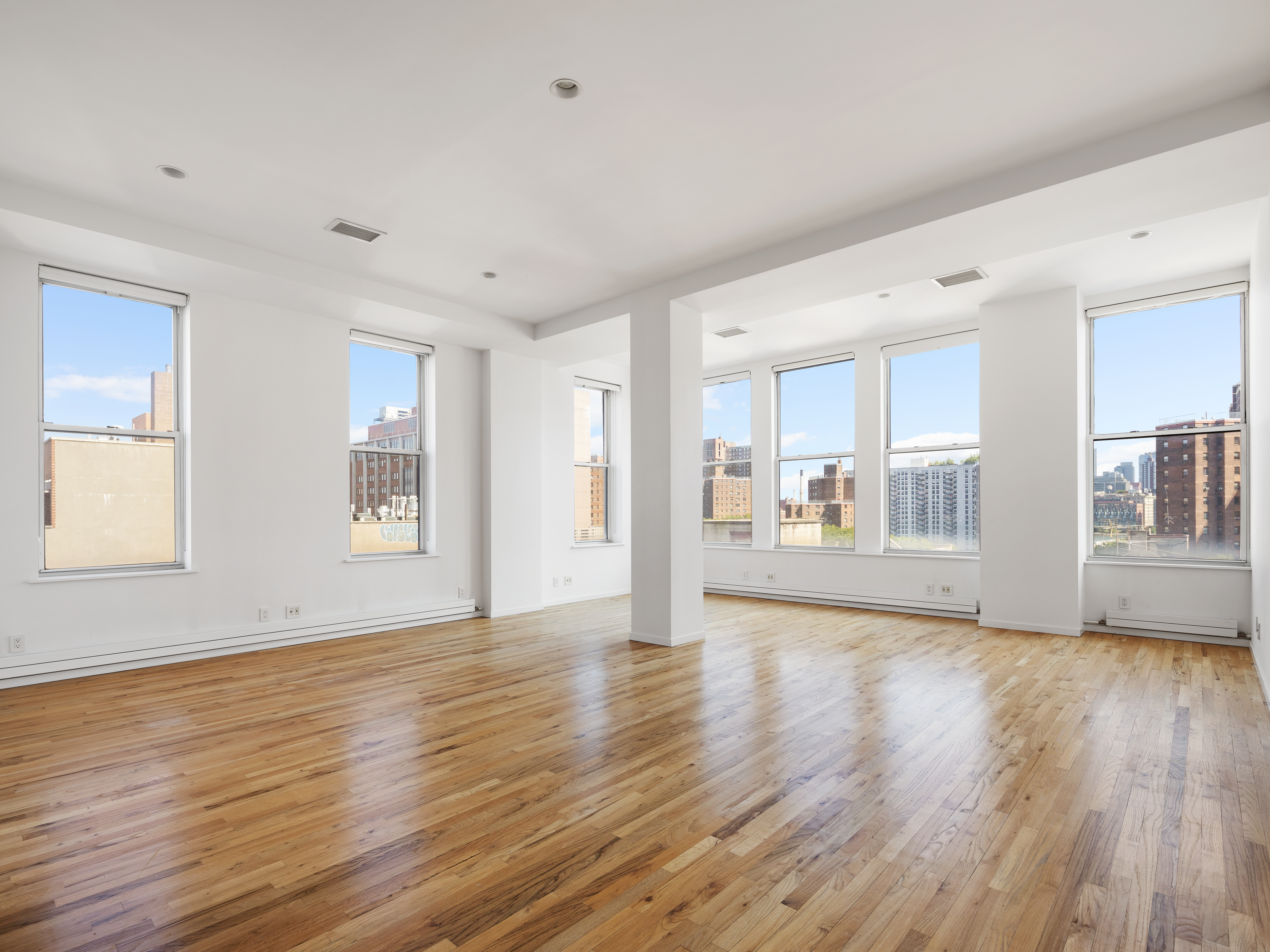 175 East Broadway, Unit 6D Manhattan, NY 10002 - Photo 2 of 18 a view of an empty room with wooden floor and a window