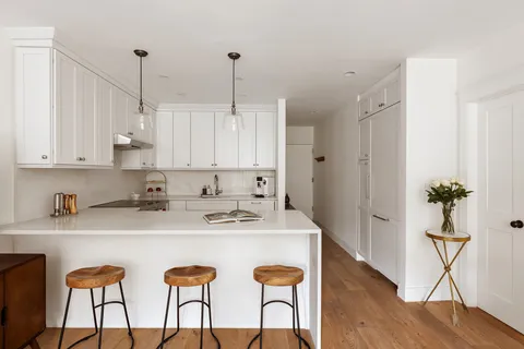 a view of kitchen with sink and refrigerator