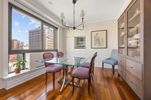 a view of a dining room with furniture a chandelier and wooden floor