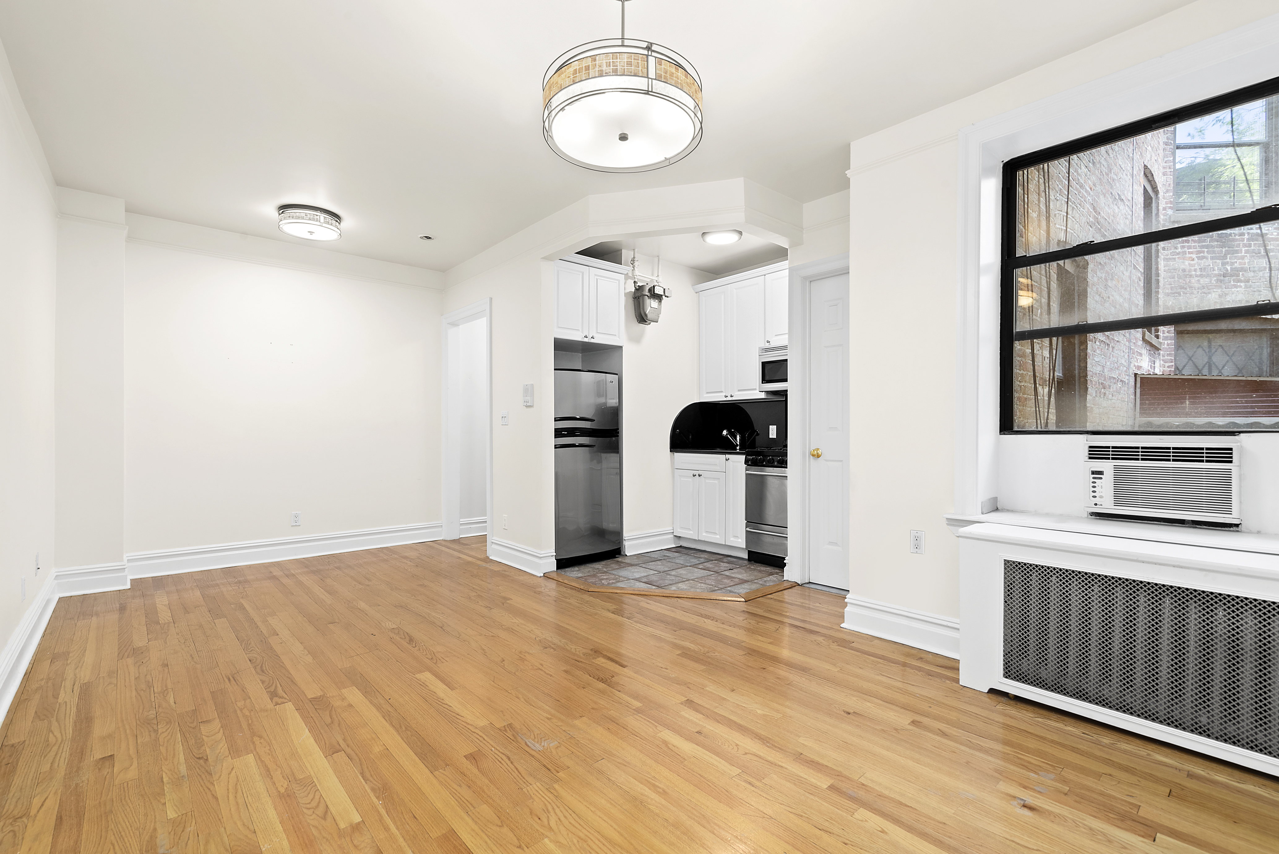 680 Riverside Drive, Unit 1E Manhattan, NY 10031 - Photo 4 of 6 a view of a room with wooden floor and white walls