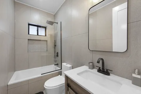 a bathroom with a granite countertop sink toilet a mirror and shower