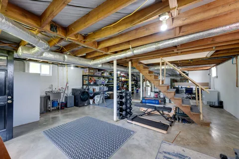 a living room with furniture a flat screen tv and gym equipment