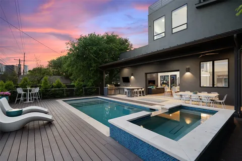 a view of a patio with dining table and chairs with wooden floor and fence