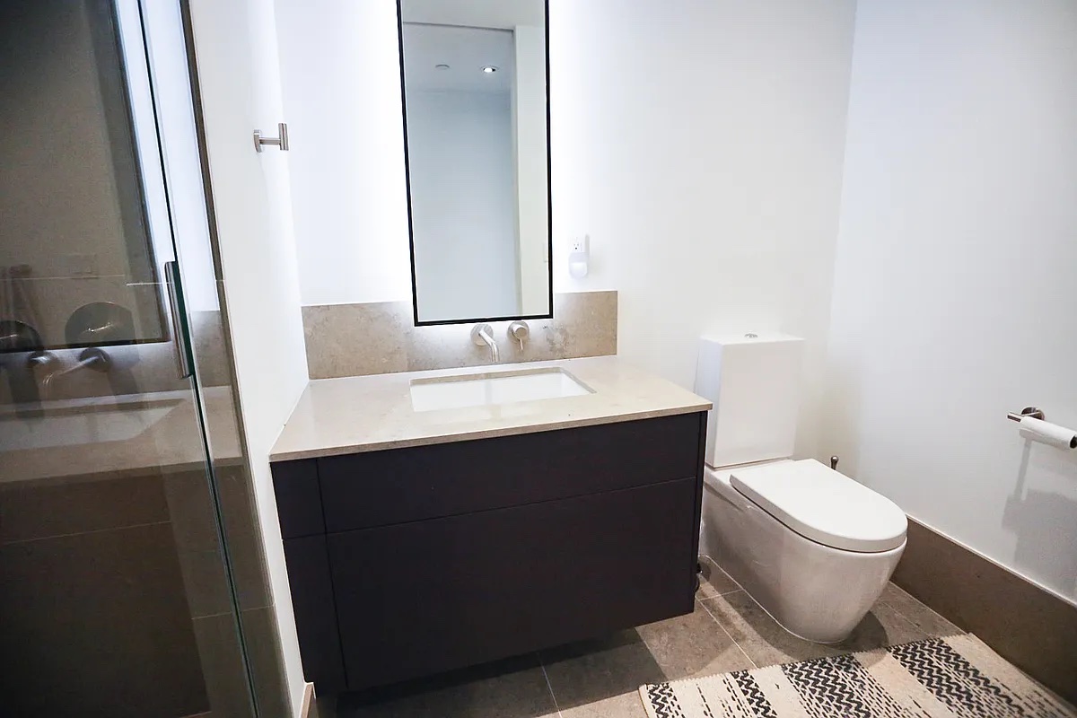 429 Kent Avenue, Unit D722 Brooklyn, NY 11249 - Photo 11 of 18 a bathroom with a sink toilet and mirror