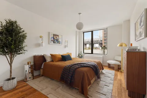 a spacious bedroom with a bed and a large window