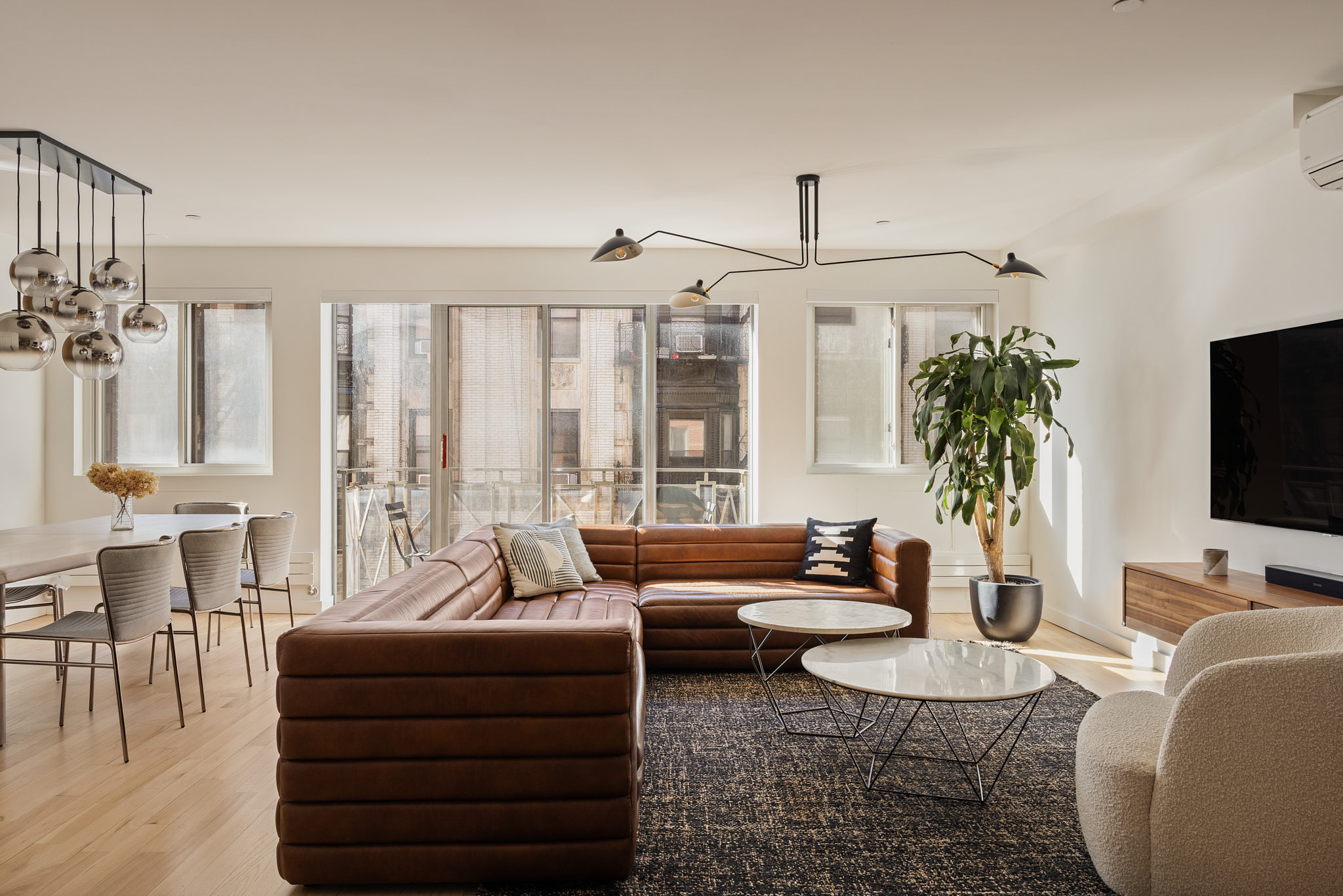 182 Mulberry Street, Unit 4 Manhattan, NY 10012 - Photo 1 of 13 a living room with furniture a flat screen tv and a large window