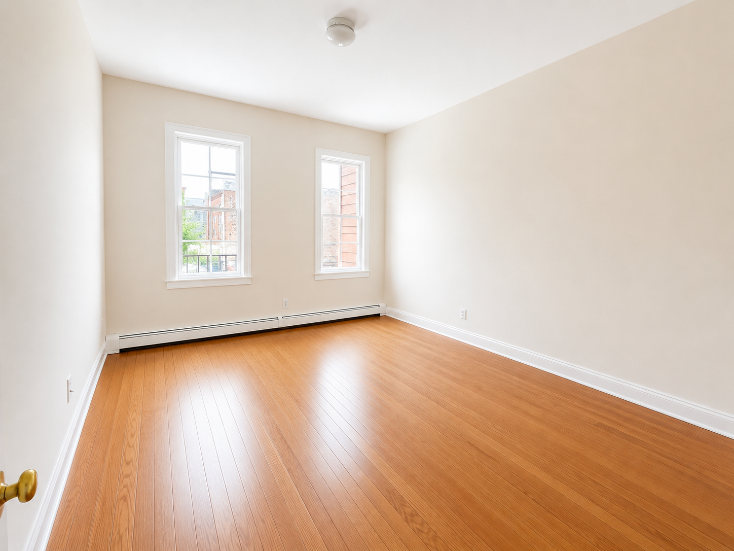 37-15 Broadway, Unit 2 Queens, NY 11103 - Photo 3 of 7 an empty room with wooden floor and windows