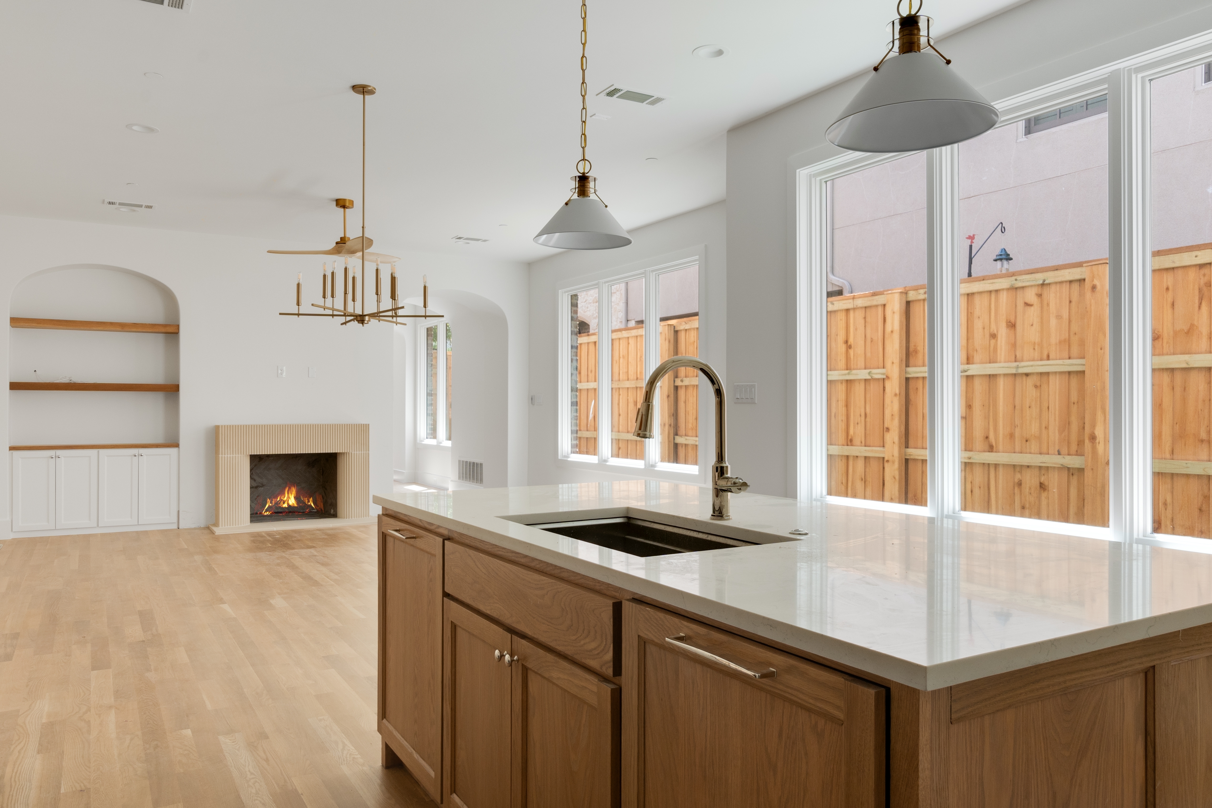 4410 Glenwick Lane Dallas, TX 75205 - Photo 5 of 28 a kitchen with a sink a chandelier and a fireplace
