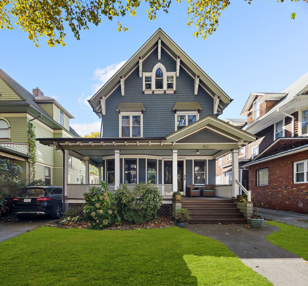 a front view of a house with a garden and trees