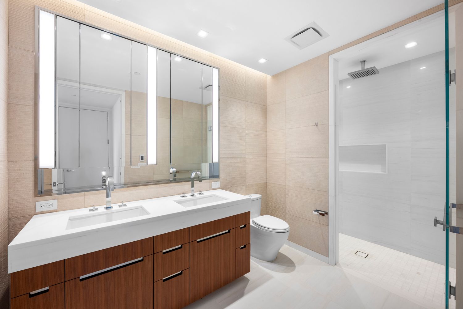 a bathroom with a double vanity sink mirror and toilet