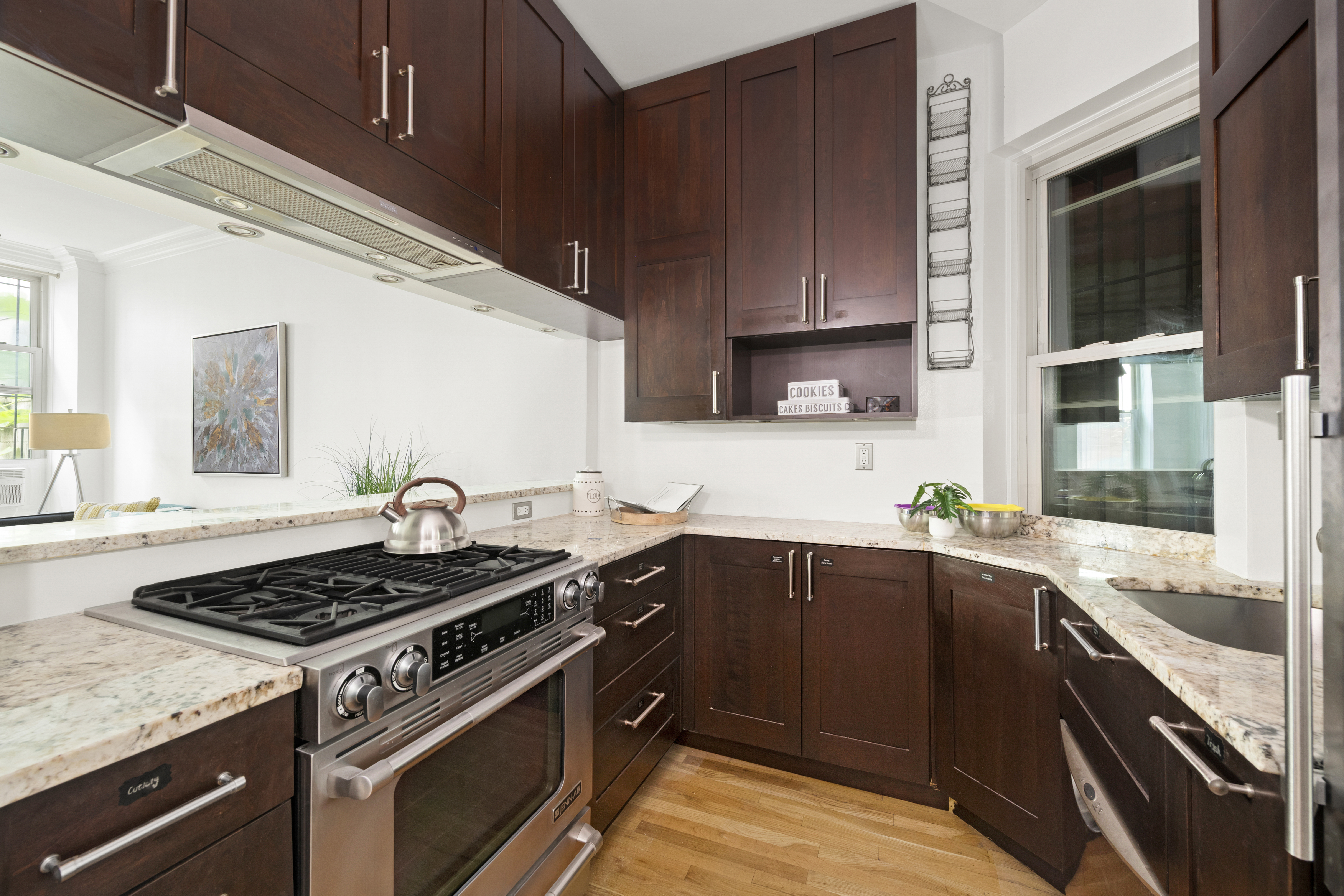 323 West 43rd Street, Unit 1R Manhattan, NY 10036 - Photo 3 of 8 a kitchen with a stove a sink and wooden cabinets