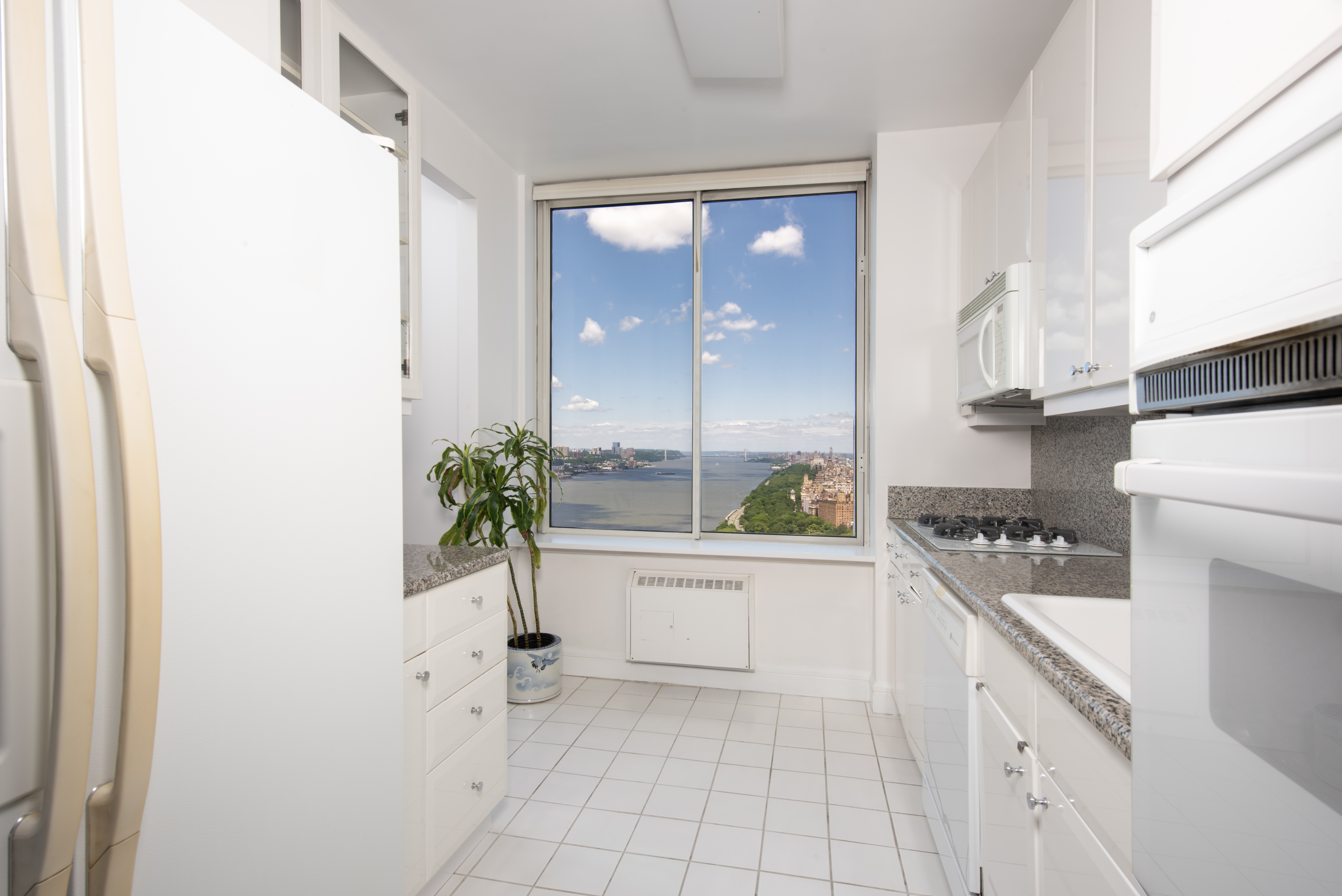 200 Riverside Boulevard, Unit PH1B Manhattan, NY 10069 - Photo 5 of 18 a kitchen with white cabinets and appliances