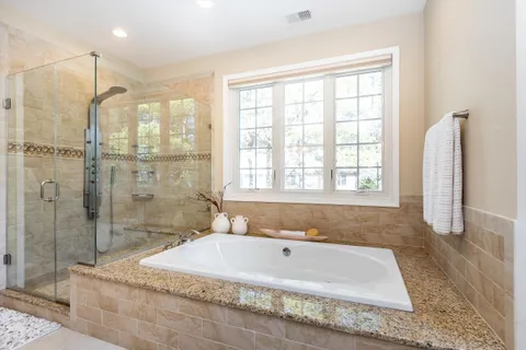 a spacious bathroom with sink shower and bathtub