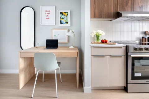 a kitchen with stainless steel appliances kitchen island granite countertop a table chairs and a refrigerator
