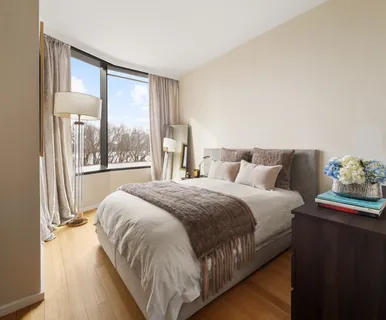 a bedroom with a bed and a large window