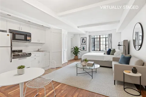 a living room with furniture a flat screen tv and a table