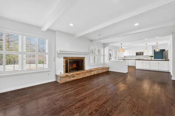 a view of an empty room with a fireplace and a window