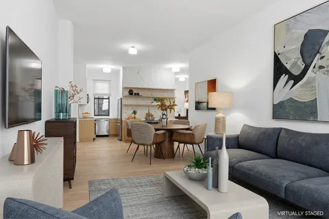 a living room with furniture kitchen view and a flat screen tv