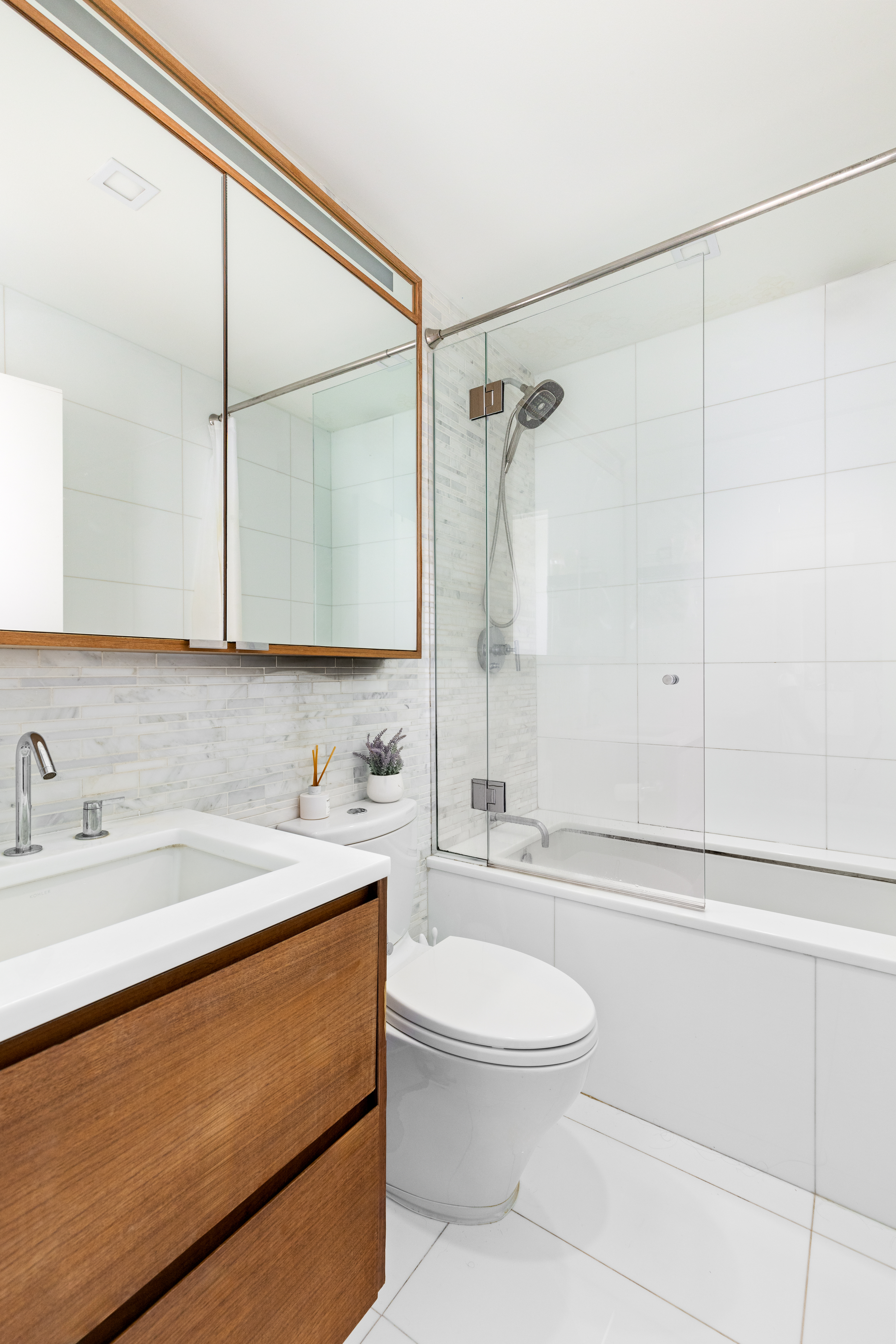 301 West 53rd Street, Unit 16D Manhattan, NY 10019 - Photo 8 of 16 a bathroom with a sink a toilet and shower