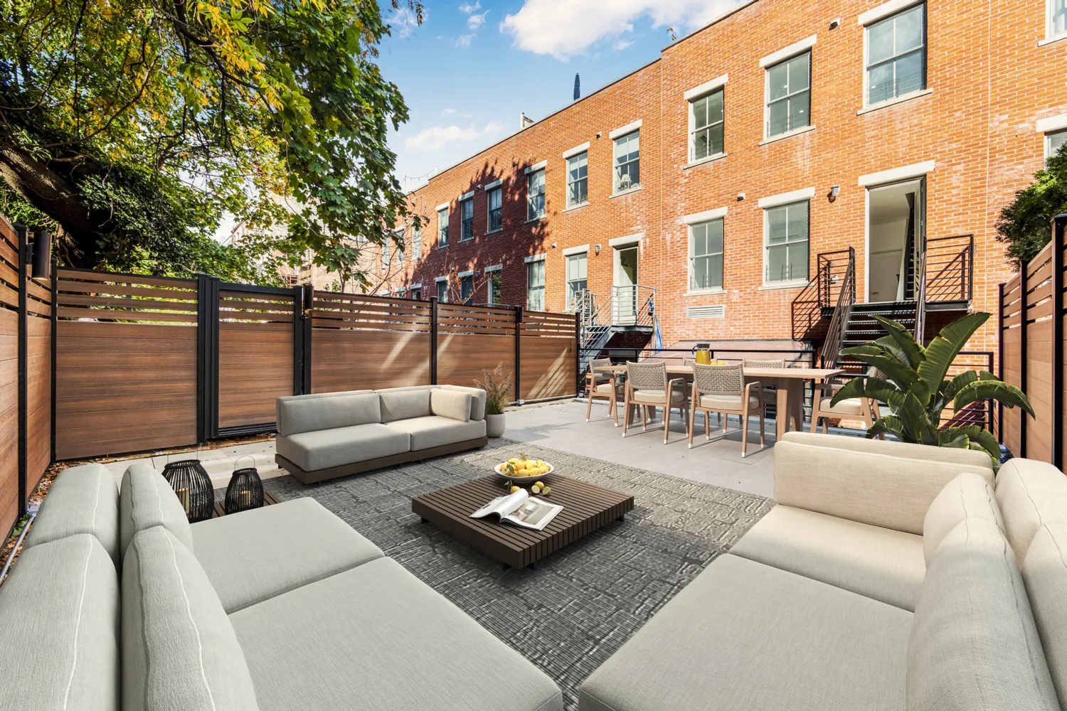 a view of a patio with couches and a table and chairs with wooden fence
