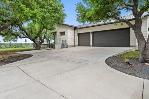 a kitchen with stainless steel appliances granite countertop a refrigerator a sink dishwasher a dining table and chairs with wooden floor