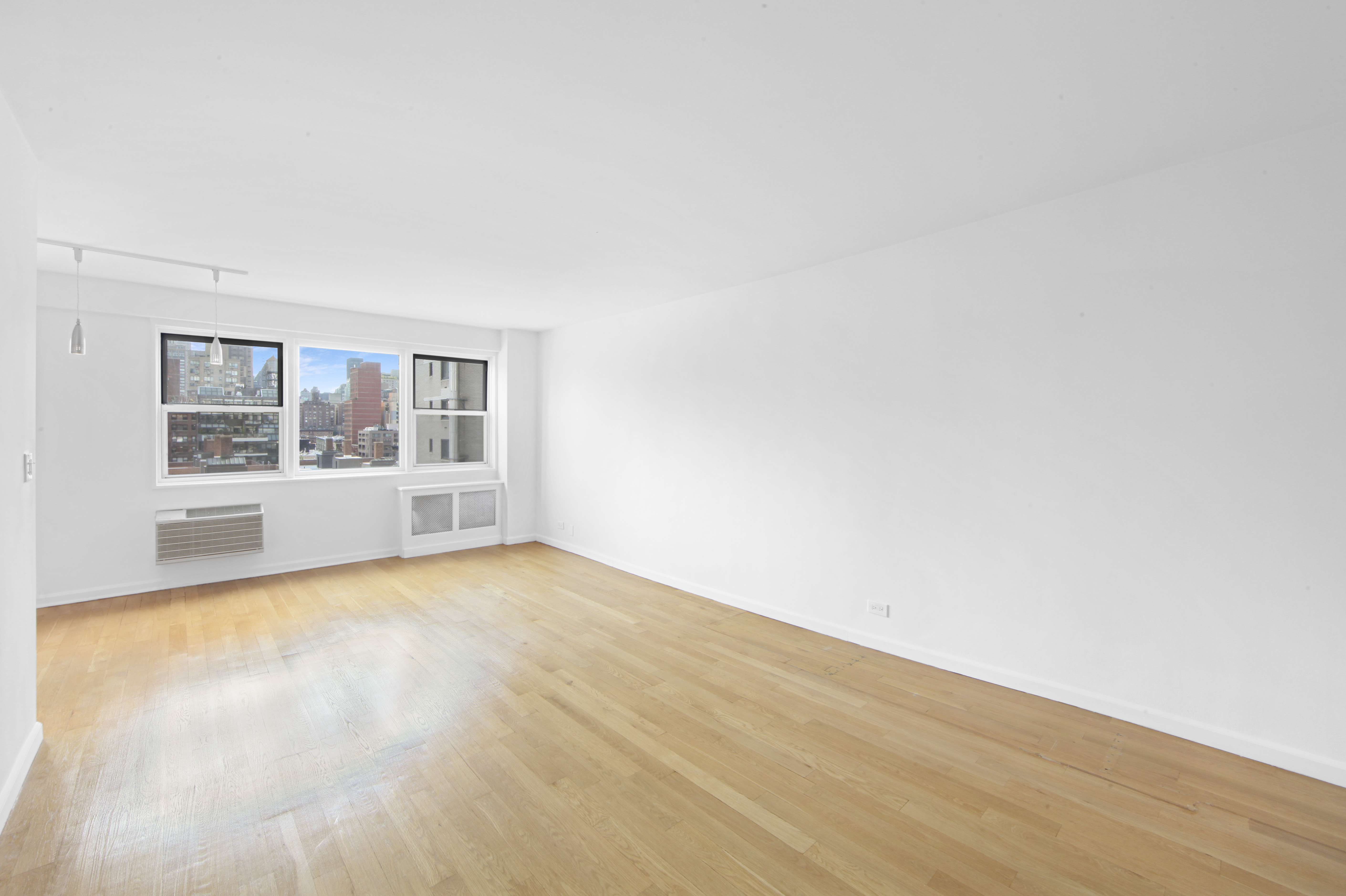 404 East 66th Street, Unit 11B Manhattan, NY 10065 - Photo 8 of 9 a view of empty room with wooden floor and fan