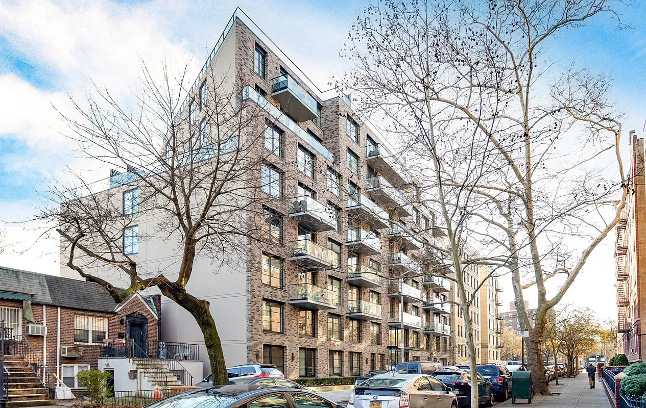 a front view of a building with large trees