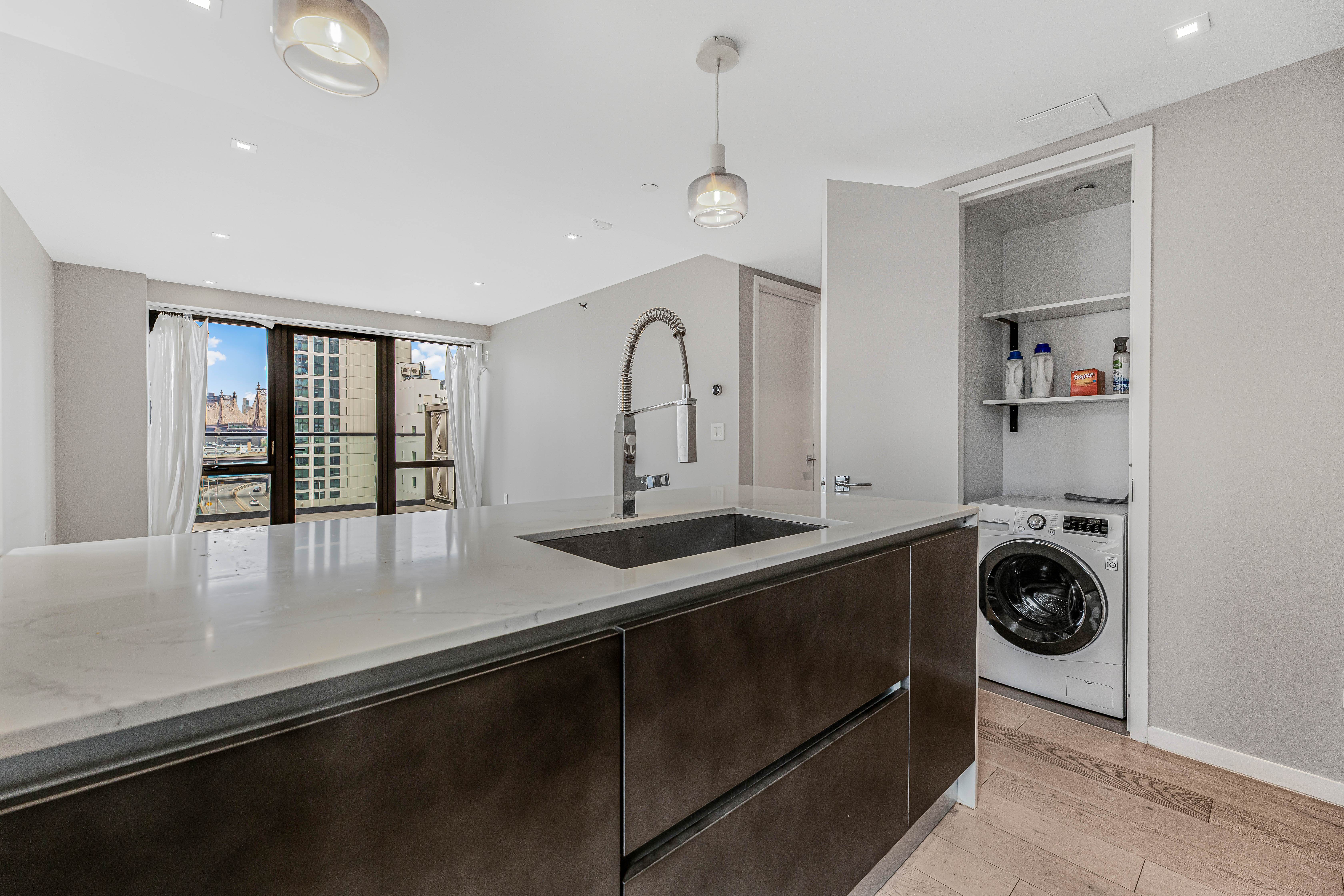 42-50 27th Street, Unit 9C Queens, NY 11101 - Photo 15 of 32 a view of a kitchen with a sink and a window