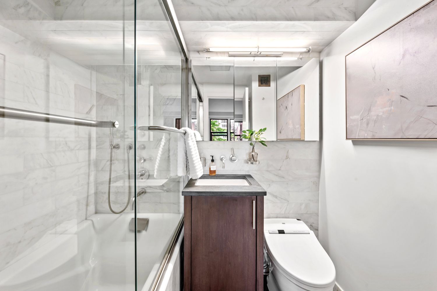 a bathroom with a granite countertop sink a toilet and shower