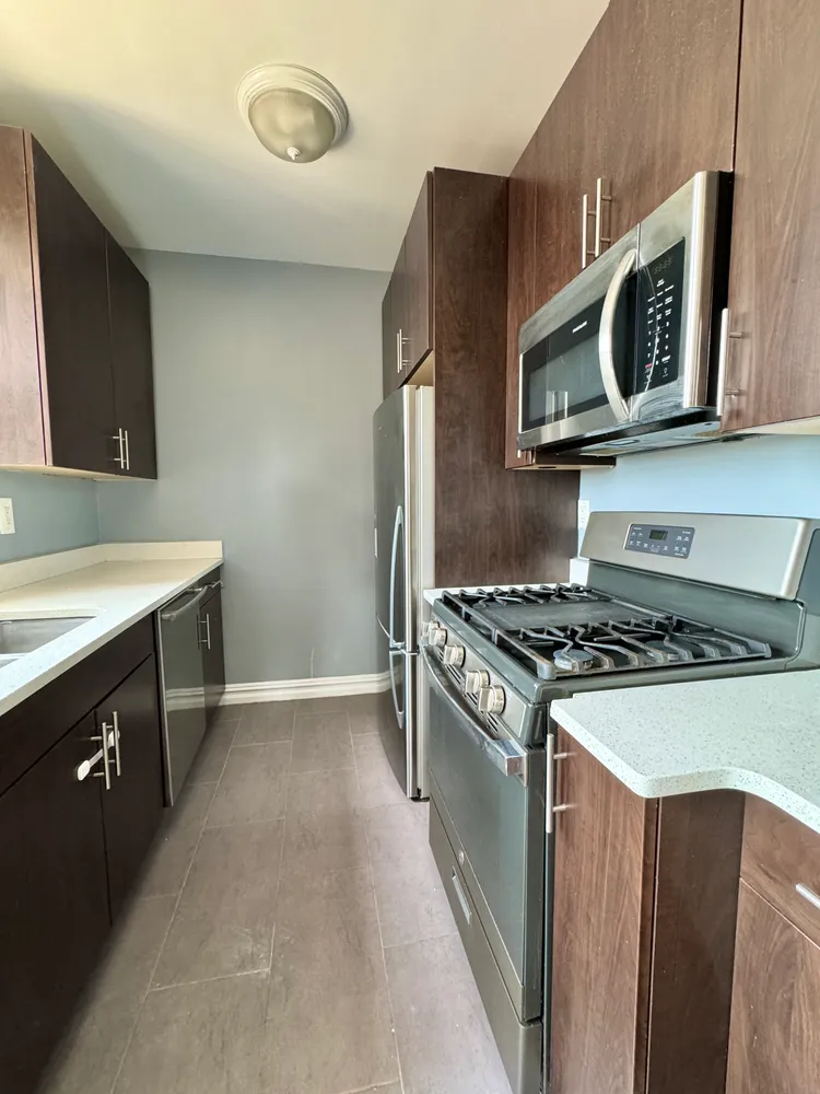 a kitchen with stainless steel appliances a stove microwave and sink