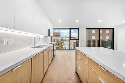 a large kitchen with kitchen island granite countertop a large window