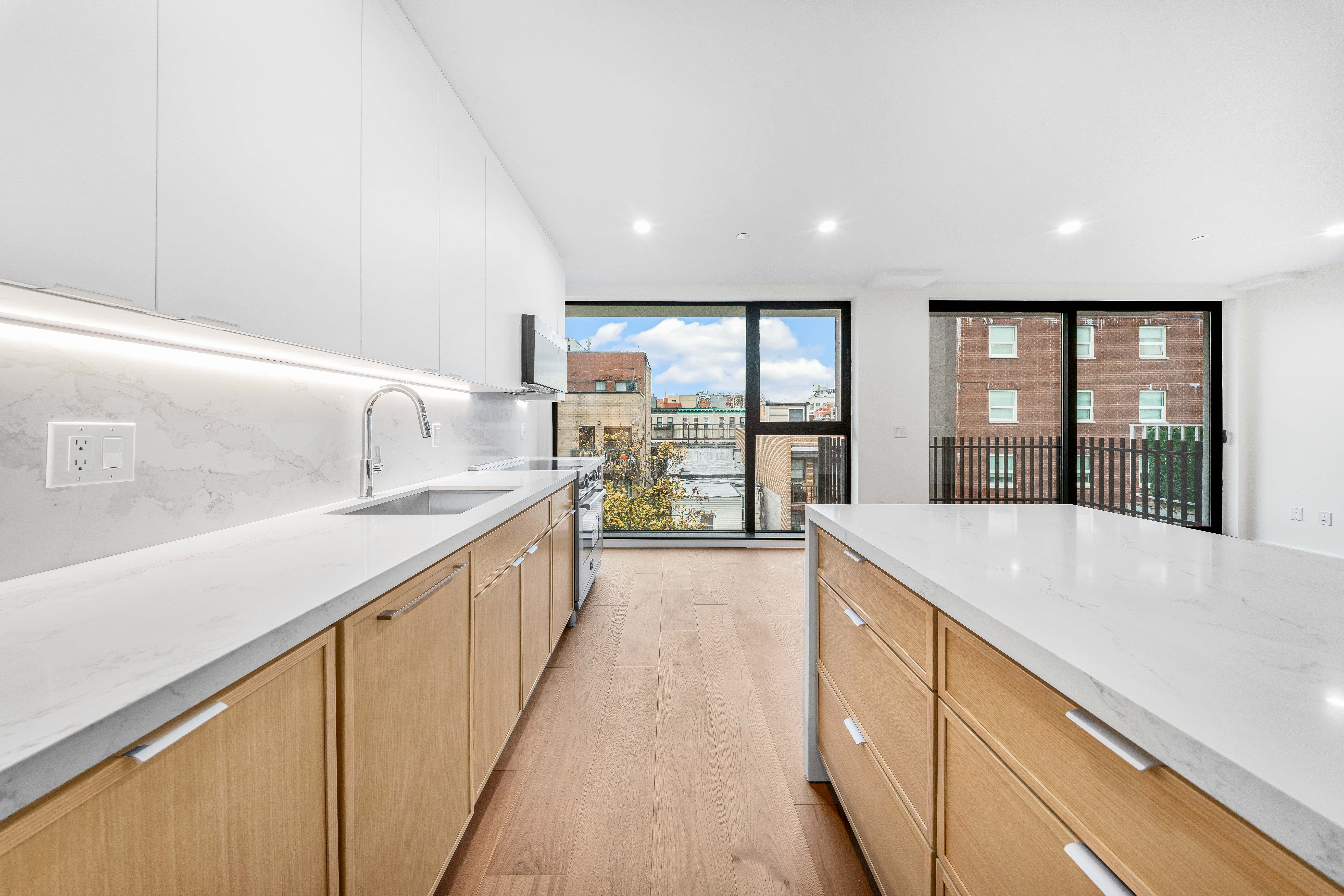 30-24 32nd Street, Unit 4A Queens, NY 11102 - Photo 3 of 22 a large kitchen with kitchen island granite countertop a large window