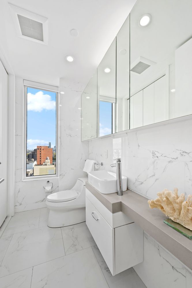 301 East 61st Street, Unit 16A Manhattan, NY 10065 - Photo 15 of 17 a bathroom with a sink a toilet and bathtub