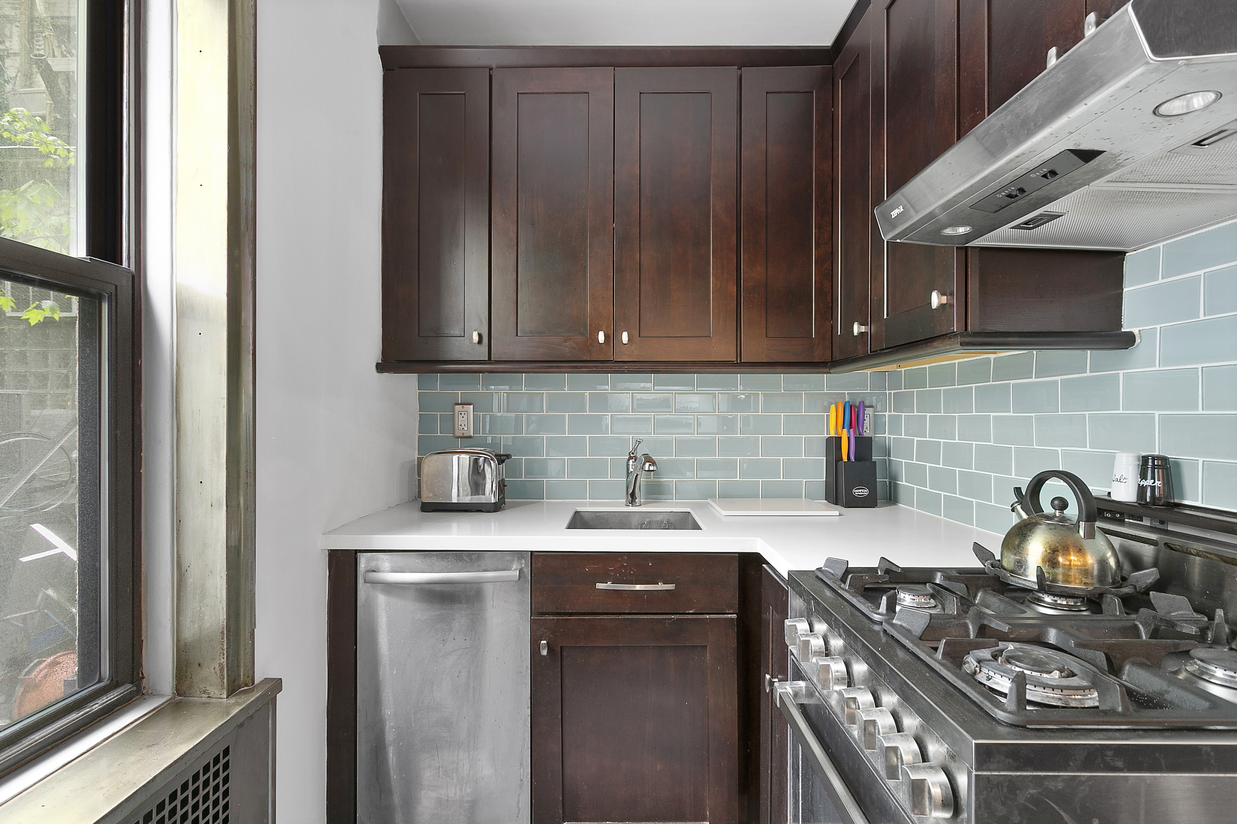 166 West 22nd Street, Unit 1F Manhattan, NY 10011 - Photo 4 of 7 a kitchen with a sink stove and cabinets