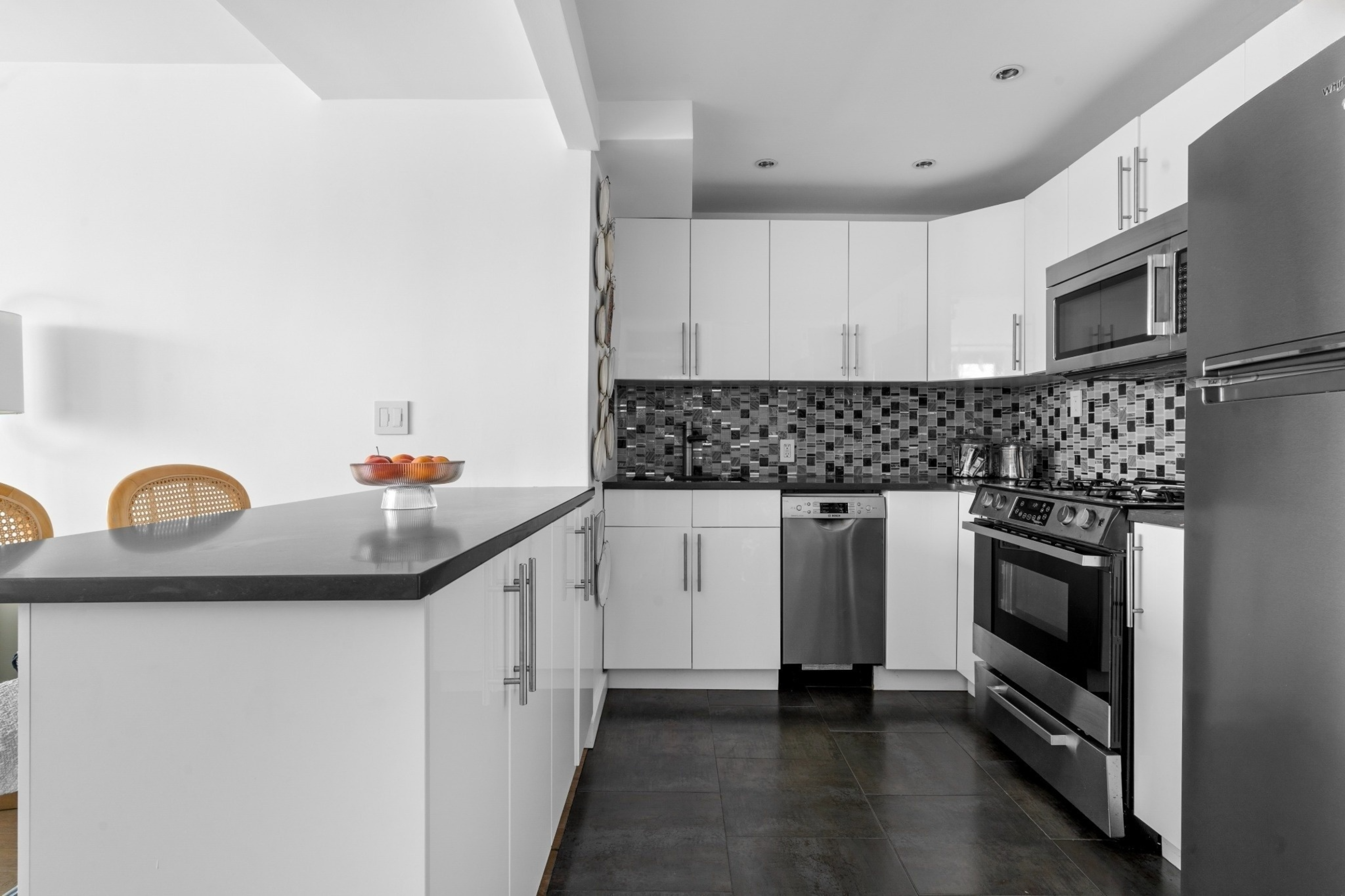 61 Jane Street, Unit 19E Manhattan, NY 10014 - Photo 2 of 9 a kitchen with granite countertop white cabinets and stainless steel appliances
