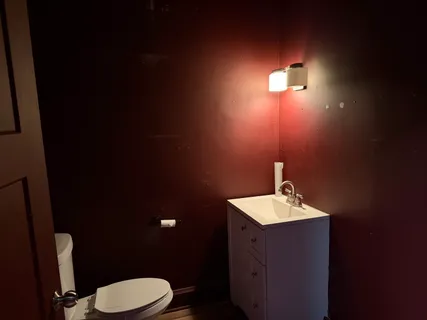 a bathroom with a toilet sink and mirror