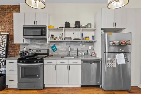 a kitchen with stainless steel appliances granite countertop a stove and a refrigerator