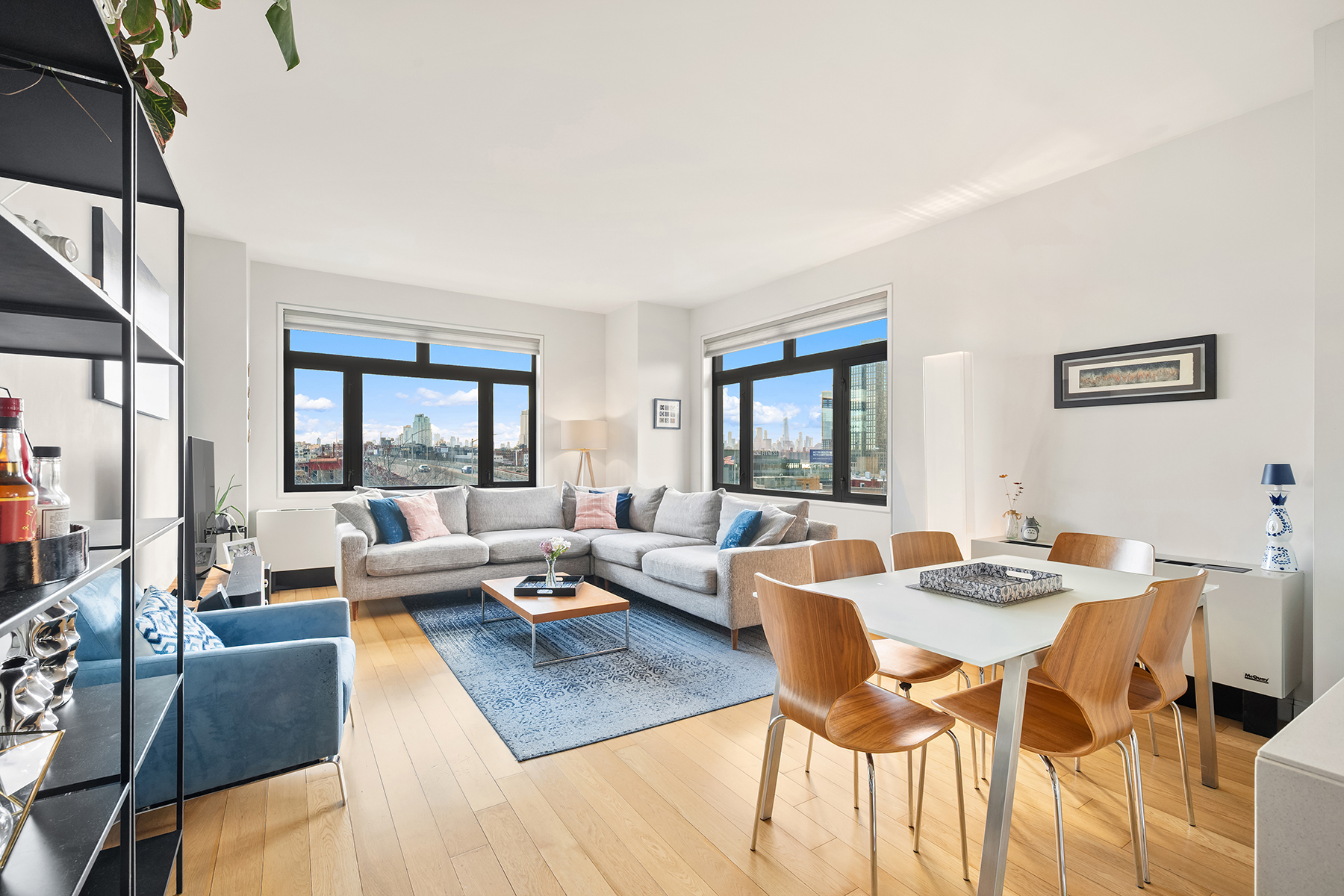 a living room with dining room and couches with wooden floor