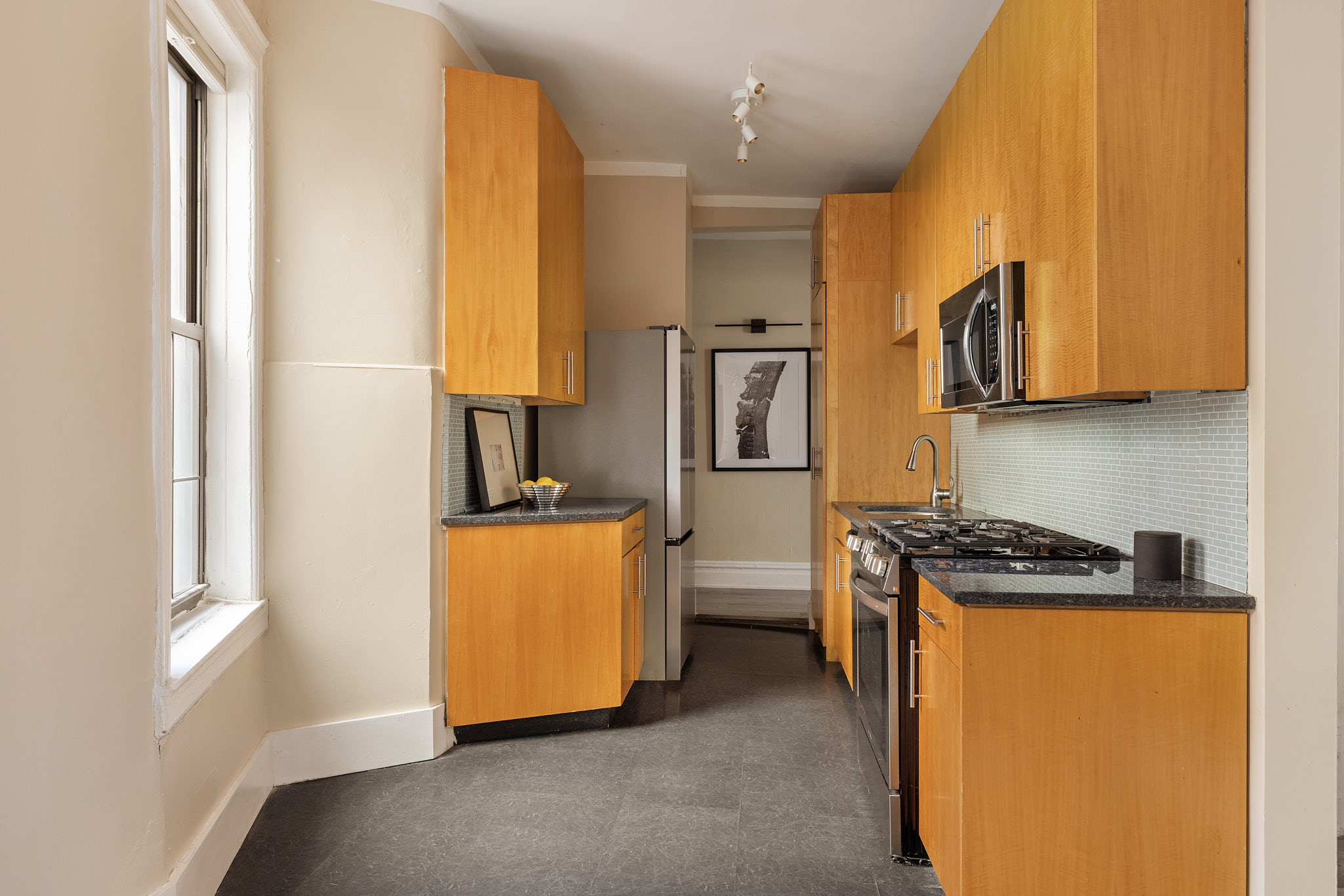 340 West 19th Street, Unit 20 Manhattan, NY 10011 - Photo 3 of 8 a kitchen with stainless steel appliances granite countertop a stove a sink and a microwave