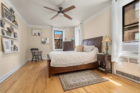 a spacious bedroom with a bed a dresser and a book shelf