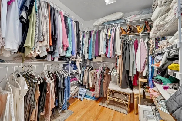 a view of walk in closet with clothes