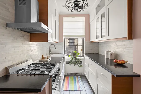 a kitchen with stainless steel appliances a stove a sink and a microwave