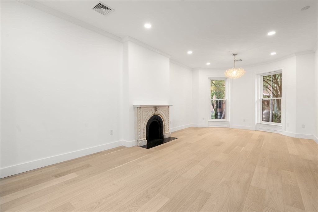 34 Worcester Square, Unit 2 Boston, MA 02118 - Photo 9 of 18 an empty room with windows and fireplace