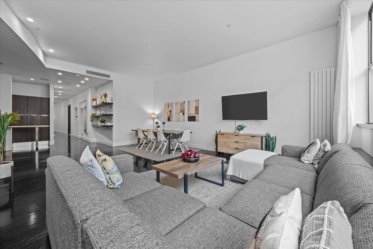 133 West 14th Street, Unit 1 Manhattan, NY 10011 - Photo 3 of 17 a living room with furniture and a flat screen tv