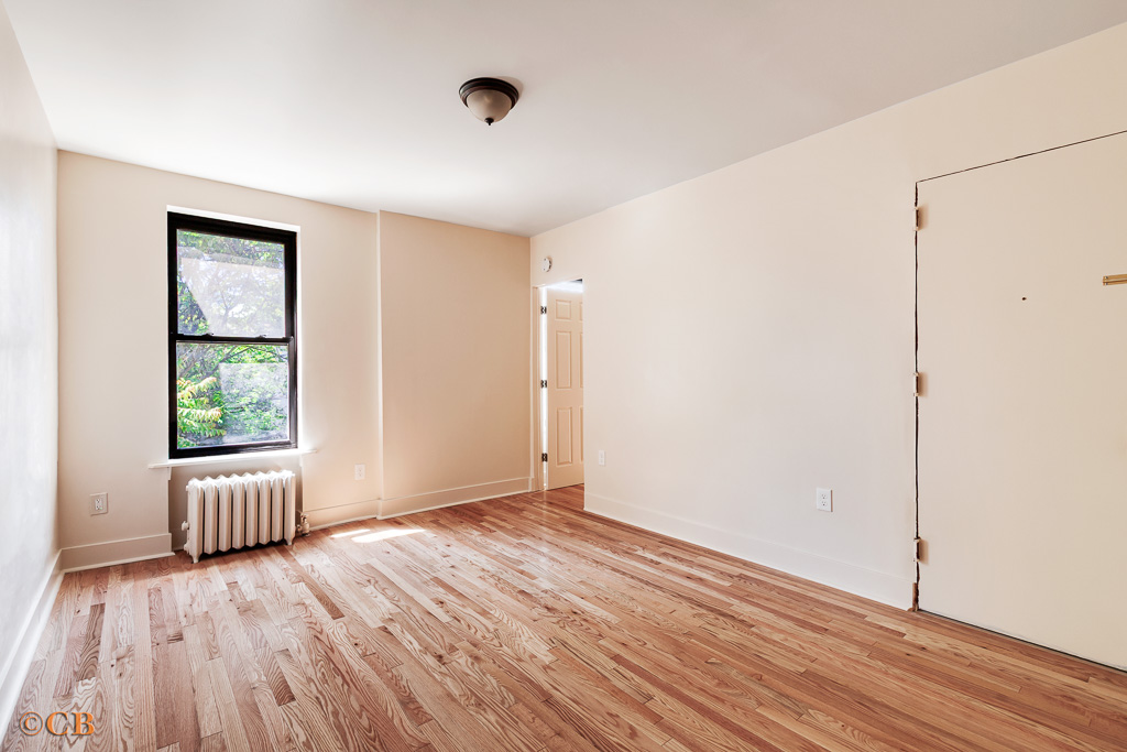 154 Hancock Street, Unit 4F Brooklyn, NY 11216 - Photo 2 of 4 an empty room with wooden floor and windows