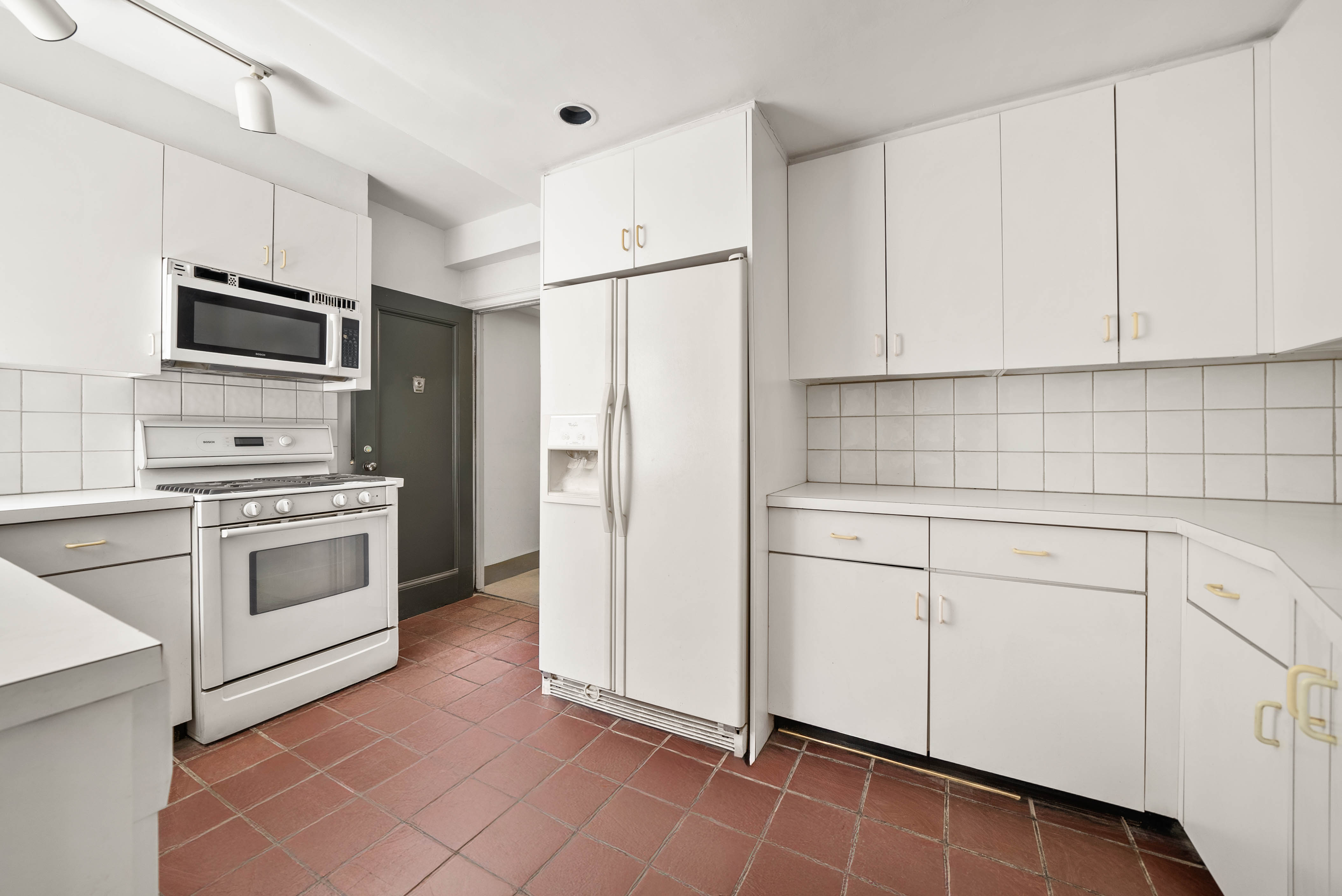 12 East 88th Street, Unit PH11/12B Manhattan, NY 10128 - Photo 12 of 22 a kitchen with stainless steel appliances white cabinets white appliances and sink