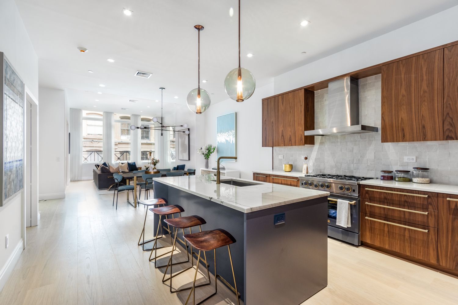 a kitchen with lots of counter space a sink appliances and living room view