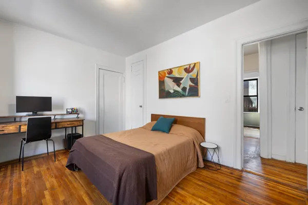 a bedroom with a bed and wooden floor